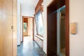 Corridor with wooden wardrobe, window and elevator door in country house Royalty Free Stock Photo