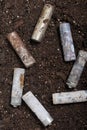 Corroded batteries covered with earth. Environmental protection and waste recycling. Close-up shot