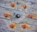 Corroded nut with washer and rusty nails on a wooden surface