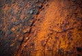 Corroding metal surface with peeling orange paint and rusty textures Royalty Free Stock Photo