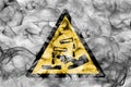 Corrosive substances hazard warning smoke sign. Triangular warning hazard sign, smoke background. Royalty Free Stock Photo