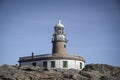 Corrubedo lighthouse, Galicia, Spain surrounded by the huge rocks Royalty Free Stock Photo