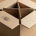 Corrugated cardboard box with partially open flaps, revealing a divider inside. The Royalty Free Stock Photo