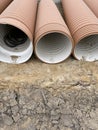 Corrugated Double-Walled Polypropylene Pipes Lined Up at a Construction Site During Daytime. Several large red Royalty Free Stock Photo