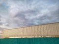 Corrugated Fence and Wall Outside Warehouse Against Cloudy Sky Royalty Free Stock Photo