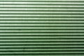Corrugated green metal plate surface.