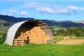 Semicircular metal barn full of hay