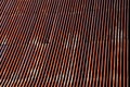 Corrugated iron roof with a lightning conductor on top. the sheet is the whole rust and forms a texture similar to Manchester fabr Royalty Free Stock Photo