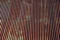 Corrugated iron roof with a lightning conductor on top. the sheet is the whole rust and forms a texture similar to Manchester fabr Royalty Free Stock Photo