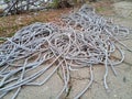 Corrugated pipes for electrical wiring lie in heap on the ground. Royalty Free Stock Photo