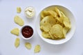 Corrugated potato chips with pepper on a white background. Delicious fast food chips. with sauce