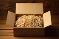 Corrugated simplicity Open box filled with sawdust on brown background