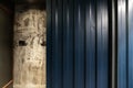 Corrugated zinc sheet facade in navy blue color compose with dirty concrete wall / architecture / seamless pattern / wallpaper Royalty Free Stock Photo