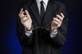 Corruption and bribery theme: businessman in a black suit with handcuffs on his hands on a dark blue background in studio isolated Royalty Free Stock Photo