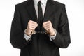 Corruption and bribery theme: businessman in a black suit with handcuffs on his hands on a white background in studio isolated Royalty Free Stock Photo