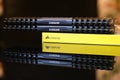 Corsair DDR RAM dual kit with two modules equipped with heatsinks, and a yellow box, reflected on a black surface - horizontal