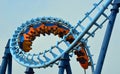 Roller coaster ride filled with thrill seekers doing corkscrew.