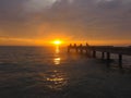 Closeup view peaceful beach with unidentified people during sunset.