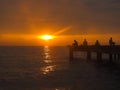 Closeup view peaceful beach with unidentified people during sunset.