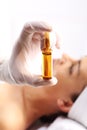 Cosmetic ampoule, a woman in the beauty salon