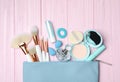 Cosmetic bag with makeup products and beauty accessories on pink background, flat lay Royalty Free Stock Photo