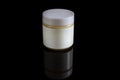 cosmetic bottle of cream with white lable and lid isolated on black Royalty Free Stock Photo