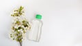 Cosmetic bottle with flowers isolated on white background. water or toner with essential oil ,top view, branding mock up and copy