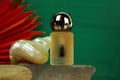 Cosmetic bottle, pearl seashell on emerald background. Stylish beauty product.