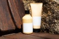 Cosmetic bottle and tube on wood and stone background Royalty Free Stock Photo