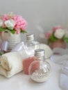 Cosmetic bottles, towel, bouquet of soap flowers on white background. Royalty Free Stock Photo