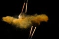Cosmetic brush with golden powder spreading on black background