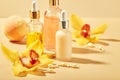 Cosmetic care products in glass bottles with orchid flowers - serums, cream, gel, oils. Concept for face and body care Royalty Free Stock Photo