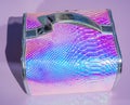 Cosmetic case on abstract background with holographic bright rainbow multicolor. Metallized macro close up. Imitation of Royalty Free Stock Photo