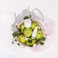 Cosmetic composition with green apples, bottles with cream and beauty accessories