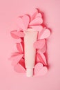 Cosmetic cream beige tube with a lot of hearts on pink background