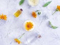 Cosmetic cream, calendula flower freshness oil on a gray concrete backgroundcosmetic cream, calendula flower oil homemade