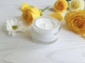 Cosmetic cream, glass yellow rose ointment care revitalize on a table white wooden background