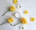 Cosmetic cream, glass yellow rose product ointment face care revitalize on a table white wooden background
