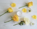 Cosmetic cream, glass yellow rose revitalize on a white wooden background