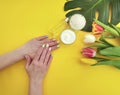 Cosmetic cream, hands summer manicure essence monstera leaf on yellow colored paper Royalty Free Stock Photo