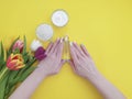 Cosmetic cream, hands on yellow colored paper Royalty Free Stock Photo