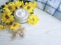 Cosmetic cream in a jar yellow chrysanthemum flower white wooden, daisy, salt, towel Royalty Free Stock Photo