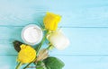 Cosmetic cream, lotion health rose flower on a blue wooden background