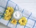 Cosmetic cream organic morning skincare yellow chrysanthemum flower white wooden, daisy, towel Royalty Free Stock Photo