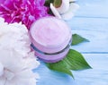 Cosmetic cream, peony flower lotion on a blue wooden background Royalty Free Stock Photo