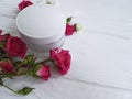 Cosmetic cream with roses a white wooden background Royalty Free Stock Photo