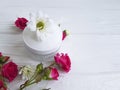 Cosmetic cream with roses on a white wooden background Royalty Free Stock Photo