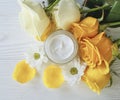 Cosmetic cream, glass yellow rose care revitalize on a table white wooden background