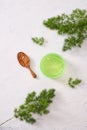 Cosmetic creams with leaves on white wooden table background