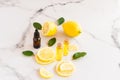 Cosmetic lemon oil and citrus essential oil on a marble table. fruits of fresh lemon and melisa leaves. cosmetics of nature in Royalty Free Stock Photo